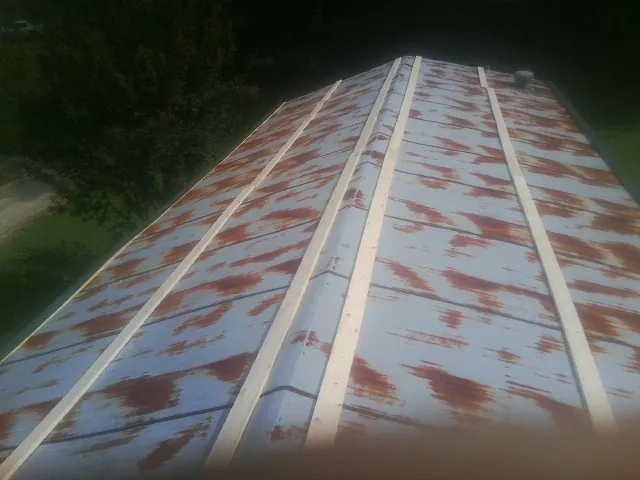 Rusted metal roof panels with new wood purlins before replacement — Storm Damage Roof Repair in Southside by Roofing Brothers