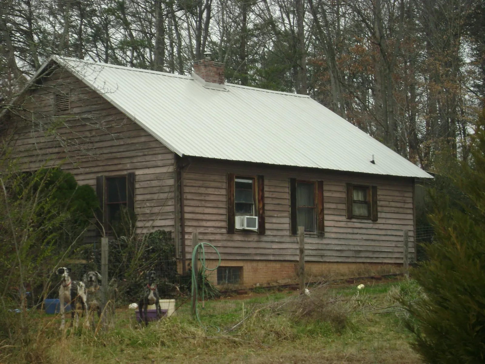 White metal roof on an old wood sided farmhouse, from a Metal Roof Installation job in Southside